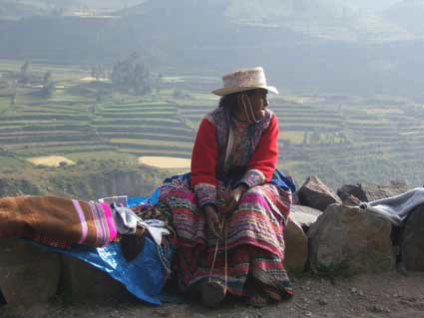 peruvian national sitting on rock edge by Insider Tours
